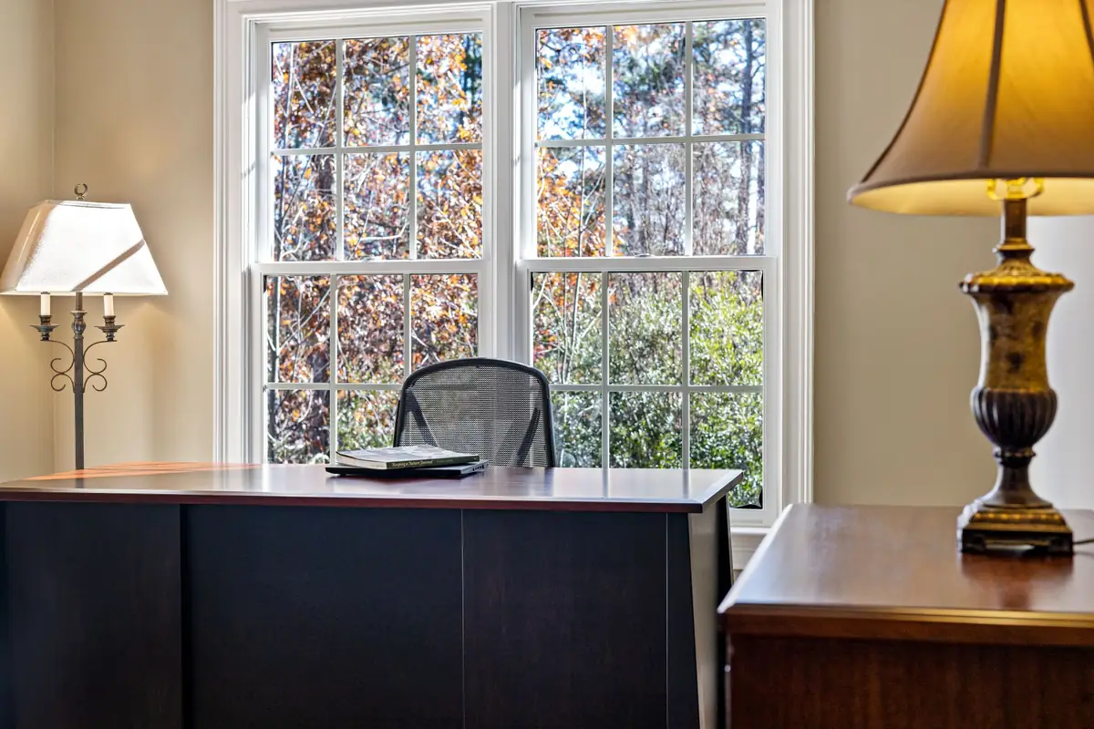 A quiet corner of the firm's office with a wooden desk and tall windows onto trees