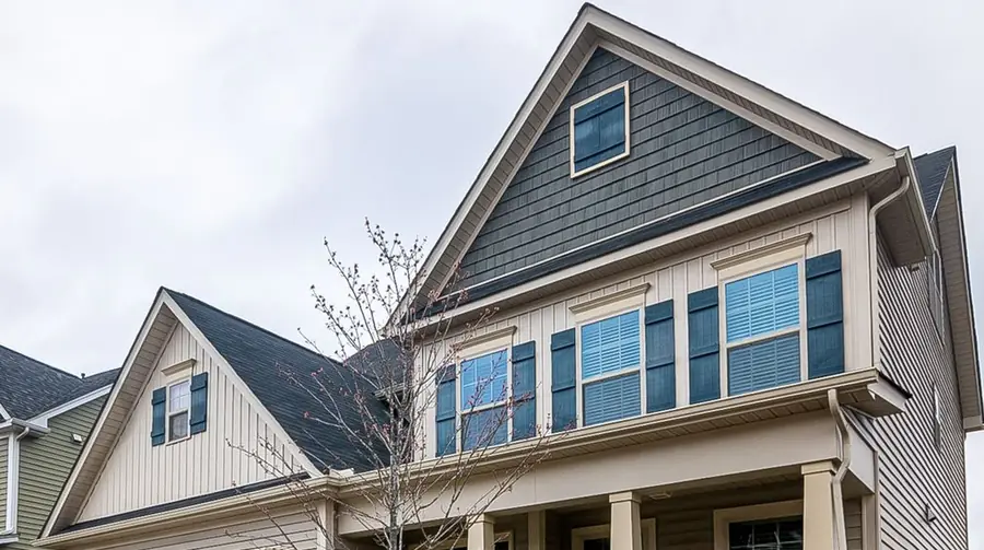 Charcoal shingle roof over a gabled home with dark shutters