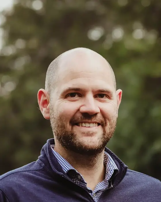 Greg Whitaker, owner and lead designer, smiling outdoors